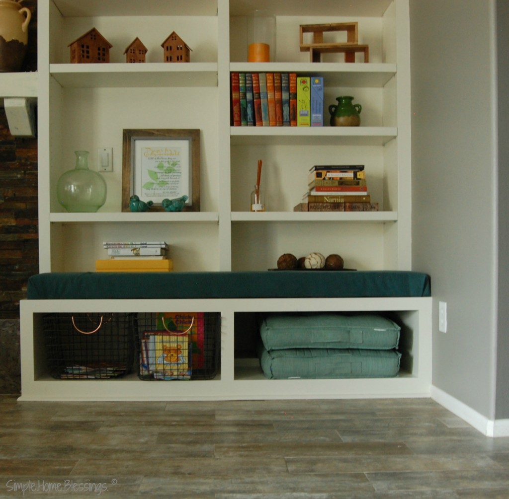 Living Room Organization - adding bins to the bottom shelf to store books and create a reading space